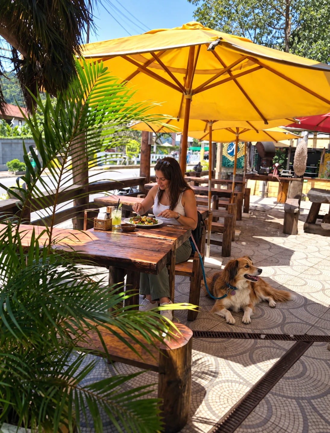 Cliente almoçando no espaço pet friendly do Olicio's com seu cachorro ao lado
